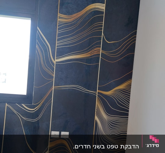 קיר עם טפט כהה ודוגמאות קווים מוזהבים